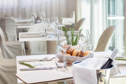 a table with a bowl of bread and glasses on it at Hotel San Giorgio Resort 4S in Caorle