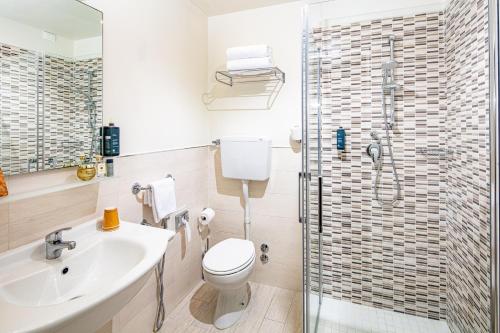 a bathroom with a shower and a toilet and a sink at Hotel San Giorgio Resort 4S in Caorle