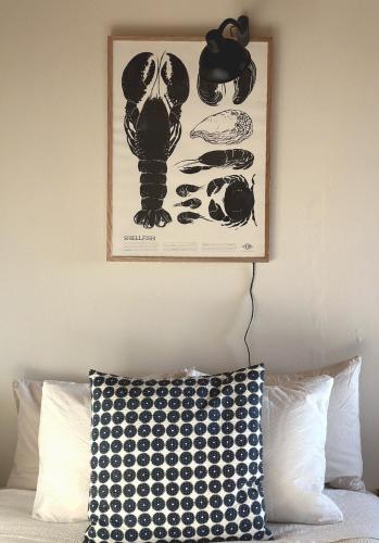 a picture on the wall above a bed with a pillow at Atelier Blå houses in Rösselvik