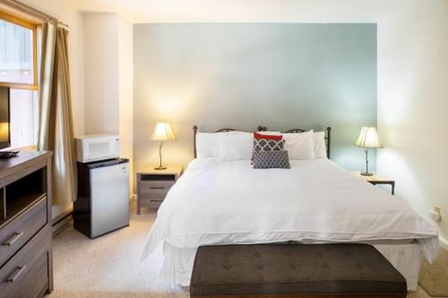 een slaapkamer met een groot wit bed en twee lampen bij Cimarron Lodge 50 by AvantStay Ski-InSki-Out Property in Complex w Two Hot Tubs in Telluride