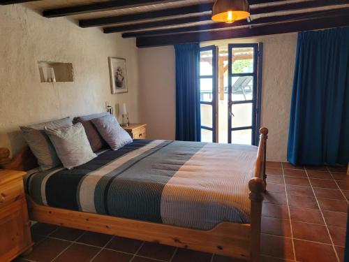 une chambre avec un grand lit avec des rideaux bleus dans l'établissement Holiday home Bois de la Borde with private pool, à Cancon