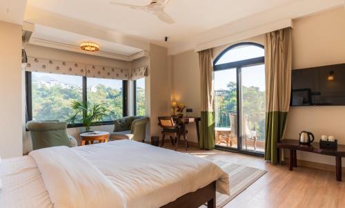 a bedroom with a large bed and a large window at Chakk 109 Mussoorie Foothills, Dehradun in Dehradun