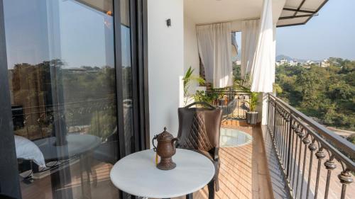 a balcony with a table and chairs and a view at Chakk 109 Mussoorie Foothills, Dehradun in Dehradun