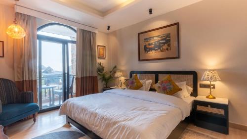 a bedroom with a bed and a large window at Chakk 109 Mussoorie Foothills, Dehradun in Dehradun