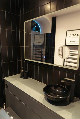 a bathroom with a black sink and a mirror at Stunning Town Centre Apartments with Spa facilities in Morpeth