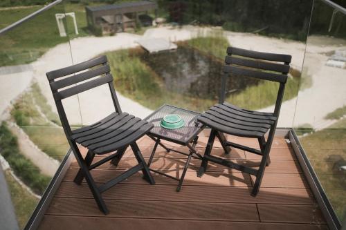 two chairs and a table on a balcony at Tornácos Hotel - Hegykő in Hegykő