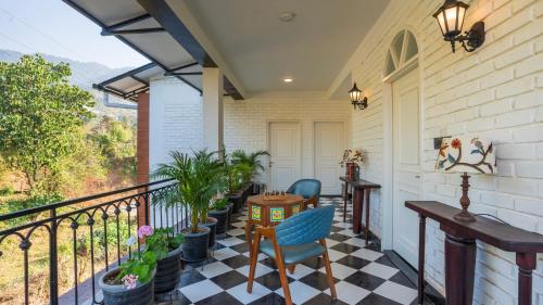 a porch with a table and chairs on a balcony at Chakk 109 Mussoorie Foothills, Dehradun in Dehradun