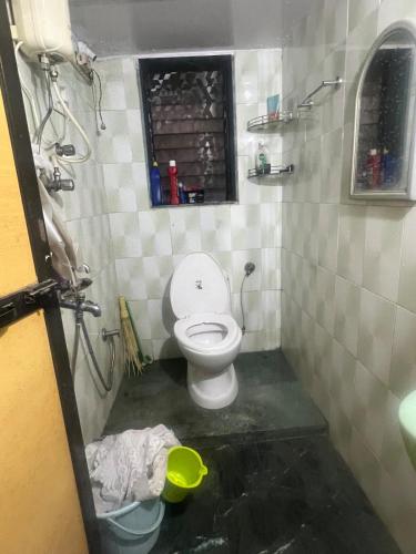 a small bathroom with a toilet and a window at 3BHK in Nerul,near DY Patil Stadium & Wonders Park in Navi Mumbai