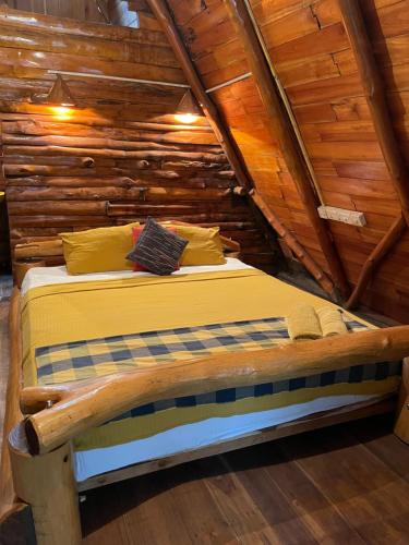 a bed in a room with a wooden ceiling at Lizard Safari Lodge in Udawalawe