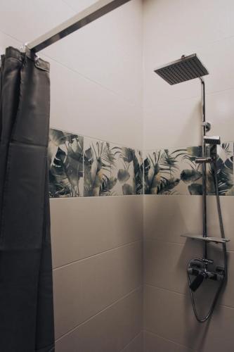 a bathroom with a shower with a black shower curtain at Zafír Vendégház in Sitke