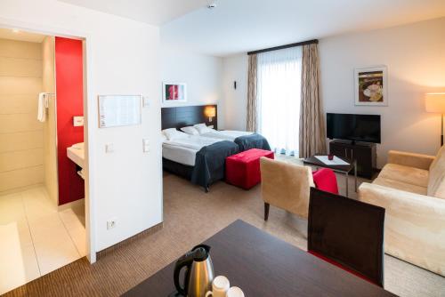 a hotel room with a bed and a living room at Best Western Plus Hotel Ostertor in Bad Salzuflen