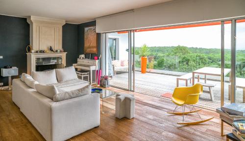 un salon avec un canapé blanc et une cheminée dans l'établissement Un havre de paix sur le Golf International d'Arcachon - vue imprenable, à La Teste-de-Buch