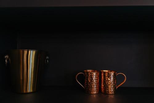 two gold coffee mugs sitting on a table at Stunning Town Centre Apartments with Spa facilities in Morpeth
