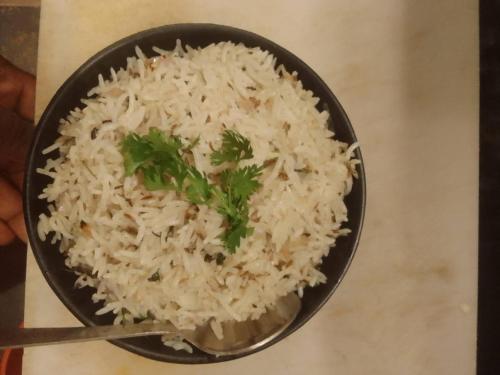 a bowl of white rice with parsley on a table at gokarna beach stay in Gokarn