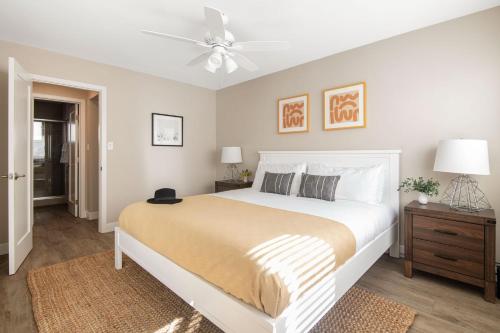 a bedroom with a white bed and a ceiling fan at Seashore Suites by AvantStay Modern Comfort Steps from La Jolla Cove in San Diego