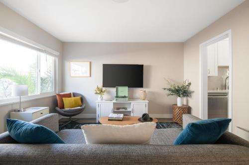 a living room with a couch and a tv at Seashore Suites by AvantStay Modern Comfort Steps from La Jolla Cove in San Diego