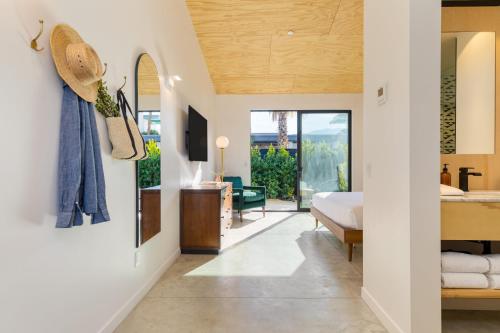 a bedroom with a king sized bed and a balcony at Blackhaus Suites by AvantStay Modern Comfort in Downtown Palm Springs in Palm Springs