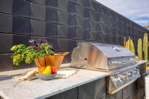 a counter with a bowl of vegetables and a grill at Blackhaus Suites by AvantStay Modern Comfort in Downtown Palm Springs in Palm Springs