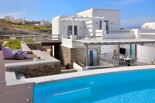 a villa with a swimming pool next to a house at Villa Sapphire 6bed with Pool and Hot Tub in Ornos in Ornos