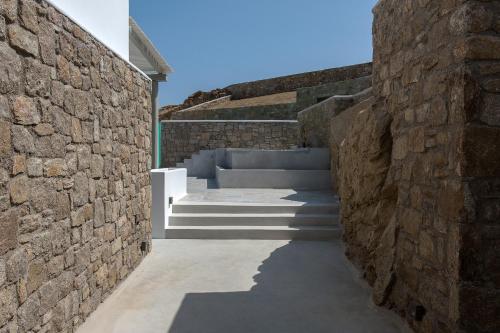 a stone wall with a staircase between two buildings at Villa Sapphire 6bed with Pool and Hot Tub in Ornos in Ornos