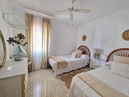 a bedroom with two beds and a table with a mirror at Next to piletas 67 Sanlucar de Barrameda in Sanlúcar de Barrameda