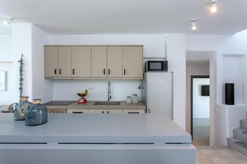 a kitchen with white cabinets and a white refrigerator at Villa Sapphire 6bed with Pool and Hot Tub in Ornos in Ornos