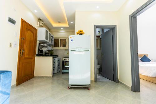 a kitchen with a white refrigerator and a bed at Lazur Pool Apartment's - El Kawsar, Hurghada - Egypt in Hurghada