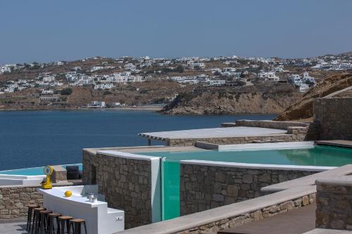 a swimming pool next to a body of water at Villa Sapphire 6bed with Pool and Hot Tub in Ornos in Ornos
