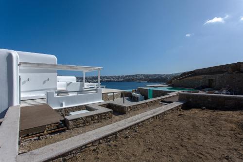 a white boat sitting on the side of the water at Villa Sapphire 6bed with Pool and Hot Tub in Ornos in Ornos