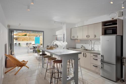 a kitchen with a island with bar stools at Villa Sapphire 6bed with Pool and Hot Tub in Ornos in Ornos