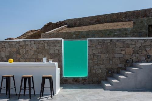 a bar with stools in front of a brick wall at Villa Sapphire 6bed with Pool and Hot Tub in Ornos in Ornos