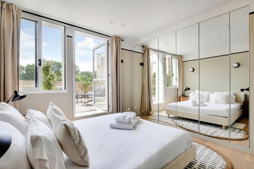 une chambre avec un grand lit blanc et de grandes fenêtres dans l'établissement Pick A Flat's Apartments in Daumesnil - Avenue du General Bizot, à Paris