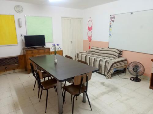 a room with a table and a bed and a chalkboard at Casa Céntrica in Cosquín