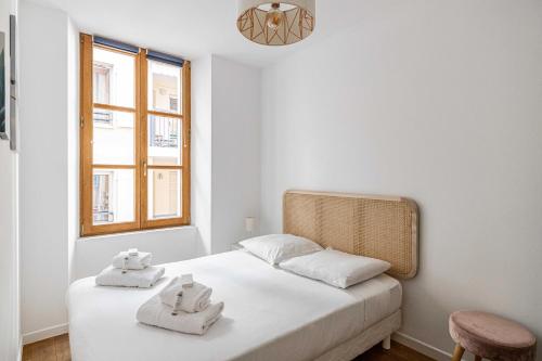 une chambre avec un lit blanc avec des serviettes dessus dans l'établissement Magnificent renovated 2 room apartment, à Cannes