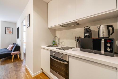 une cuisine avec un évier et un micro-ondes dans l'établissement Magnificent renovated 2 room apartment, à Cannes