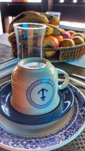 a cup of coffee on a plate on a table at Pousada Vida Simples in São Francisco do Sul