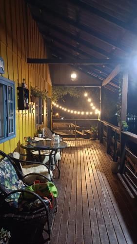 a patio with a table and chairs and lights at Pousada Vida Simples in São Francisco do Sul