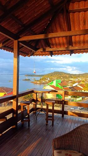 a wooden deck with a table and benches on it at Pousada Vida Simples in São Francisco do Sul