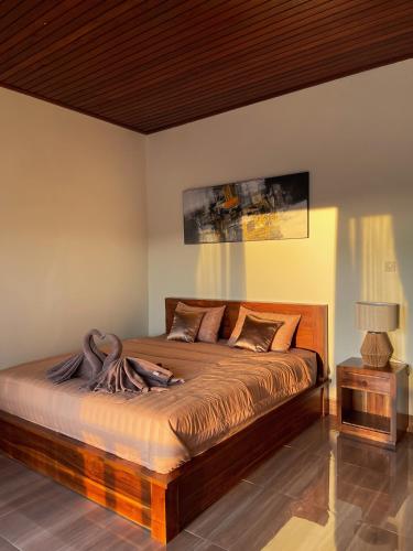 a bedroom with a large bed with a wooden headboard at Besakih villa in Besakih