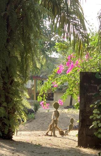 two statues of children walking in the sand under a tree at Rundbungalow auf Lionsrest in Grand-Bassam