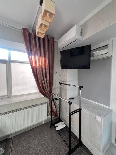 a room with a tv and a curtain and a window at Soroca Motel in Soroca