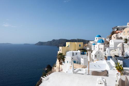 a view of a village on the side of the water at Nano Oia Villas in Oia
