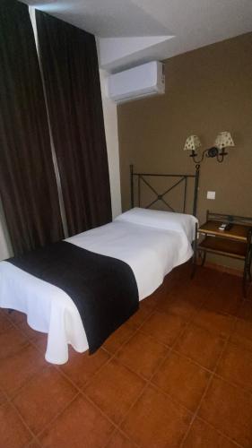 een slaapkamer met een bed met een zwart-witte deken bij Area de Servicio los Cerrillos, H-CC-651 in Peraleda de la Mata