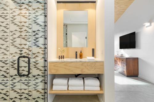 a bathroom with a sink and a mirror at Blackhaus B10 by AvantStay Modern Room Pool in Palm Springs