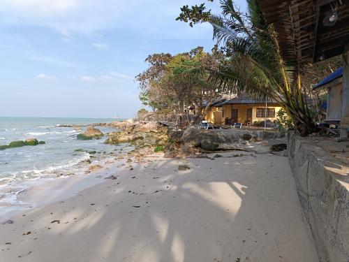 a sandy beach with a house and the ocean at TONGs HOTEL in Amphoe Koh Samui