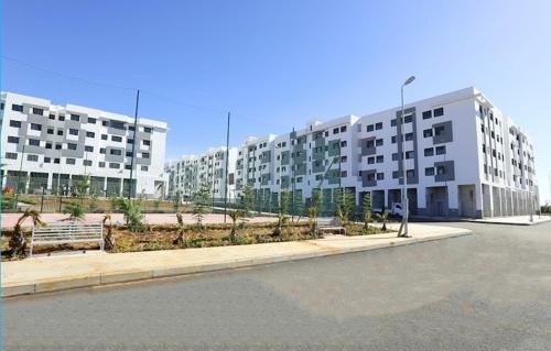 a parking lot with a large apartment building at Luxurious space in Oulad Kerroum