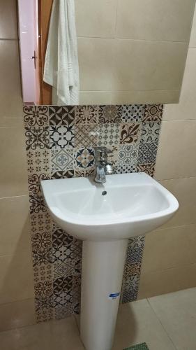 Oulad KerroumにあるLuxurious spaceのタイル張りの壁のバスルーム(白い洗面台付)