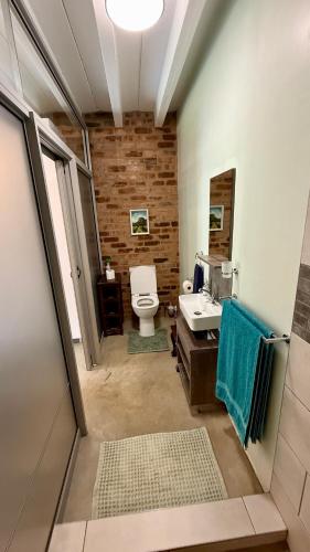 Un baño con inodoro, lavabo y espejo. en The Green Lantern - Howick, en Howick