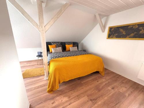 1 dormitorio con 1 cama con manta amarilla en Ferienwohnung Pauline, en Weimar