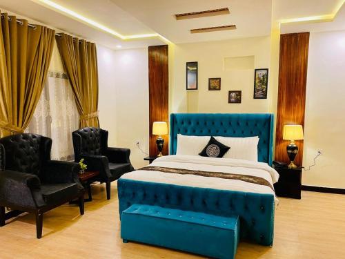 斯瓦特The Corporate Lodges Hotel by Khan Familia Travels的一间卧室配有蓝色的床和两把椅子